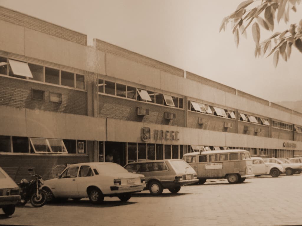 Foto histórica do prédio da Reitoria da Udesc, com carros estacionados à frente da entrada do prédio