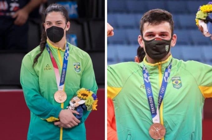 À esquerda, com um uniforme verde e amarelo, Mayra Aguiar, com sua medalha de bronze no peito eum buquê de flores nas mãos. Ela é uma mulher branca, usa tranças no cabelo e olha fixamente para a câmera. À direita, o atleta Daniel Cargnin, branco, com o uniforme da seleção brasileira, exibe sua medalha de bronze enquanto ergue os braços em celebração.