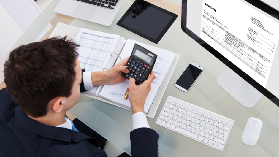 Homem usa calculadora para calcular invoice