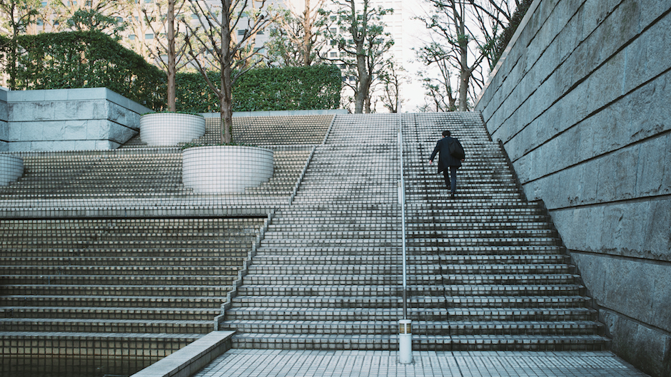 Homem de terno subindo escadas sozinho na cidade