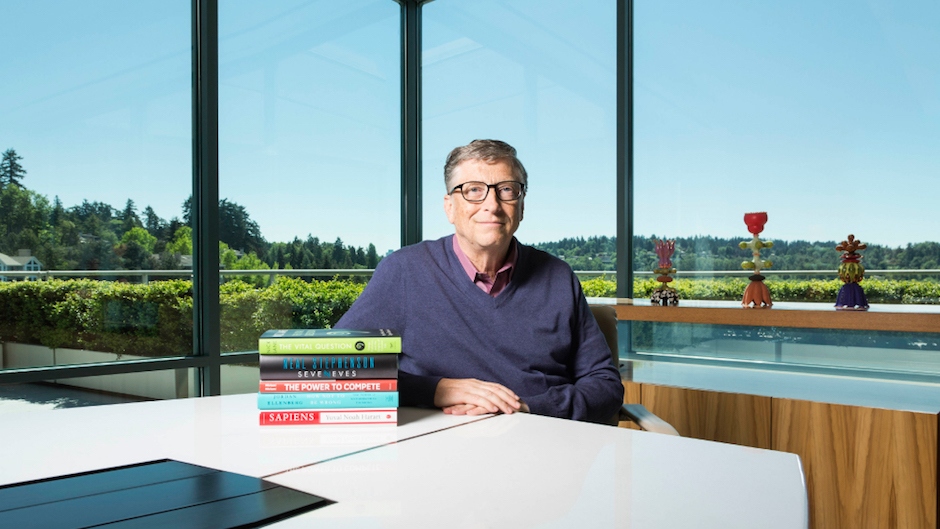 Bill Gates ao lado de uma pilha de livros