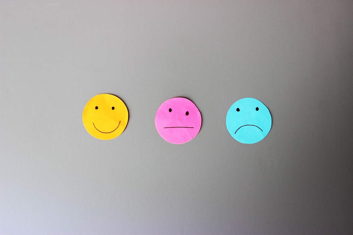 Carinhas de papel representando sorriso, neutralidade e tristeza para uso em feedback