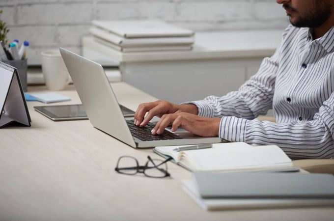 Cropped image of businessman working on laptop at his table