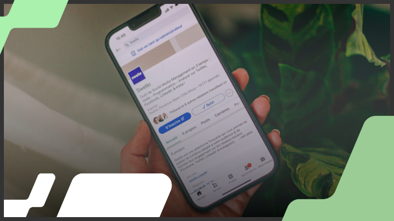 Imagem mostra uma mão segurando um smartphone, cuja tela exibe um perfil do LinkedIn