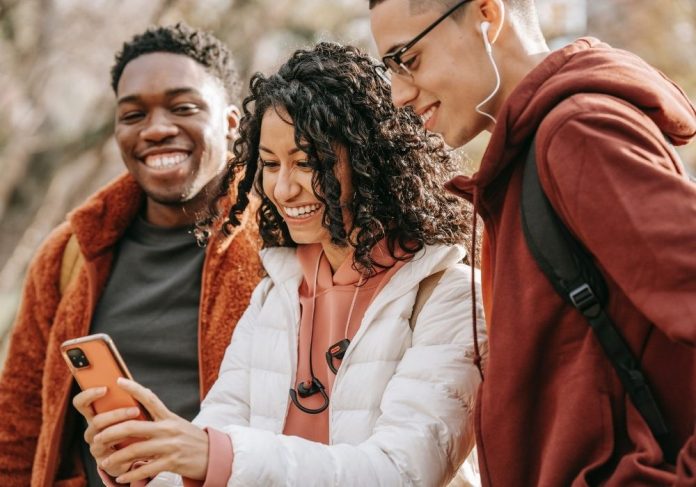 Crianças Com O Telefone Celular Exterior Dois Meninos Que Sorriem